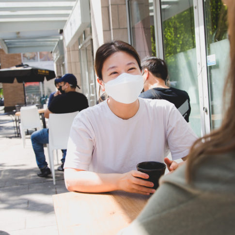 lady wearing a mask in a cafe